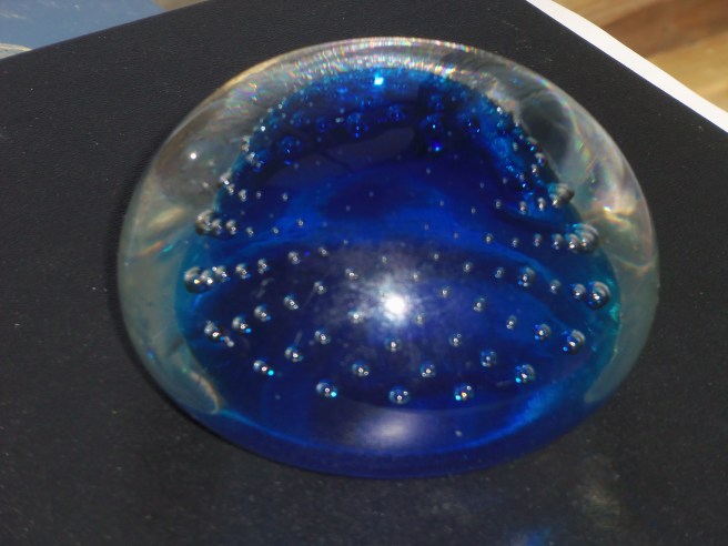 My favorite paperweight has a cobalt-colored core enveloped by clear glass. How they ever produced the swirls of bubbles remains mystifying.