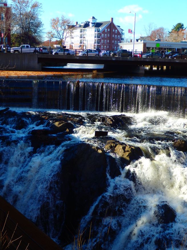 Cocheco River falls crisply over the dam and waterfalls in downtown Dover. The tide from the Atlantic Ocean reaches up to the base below.  